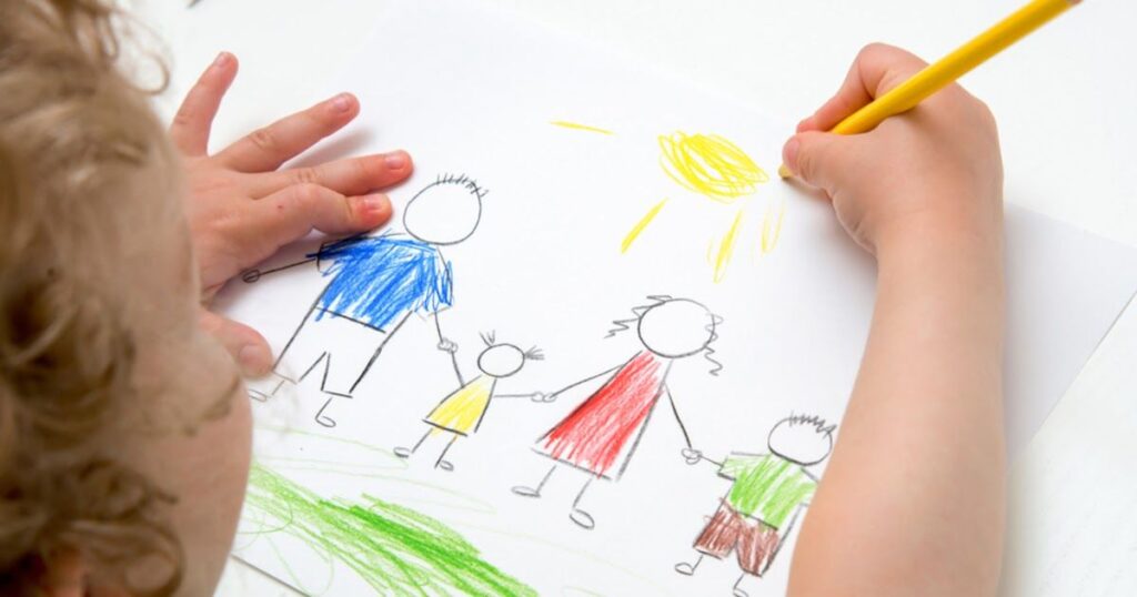 A child joyfully drawing a family on paper, inspired by "A List of the Best How to Draw Books for Kids Ages 3-8."